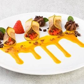 Ravioli di mango farciti con mousse al cioccolato e fragole, in salsa al coulis di mango e maraschino Ravioli di mango farciti con mousse al cioccolato e fragole, in salsa al coulis di mango e maraschino